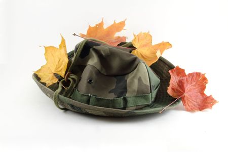A camouflage hat, isolated on white with leaves.の写真素材
