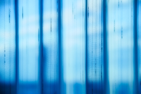 Light passing through thin drapes with vertical sections both in and out of focus.の写真素材