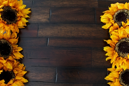 A background of wood framed by flowers providing copy space.の写真素材