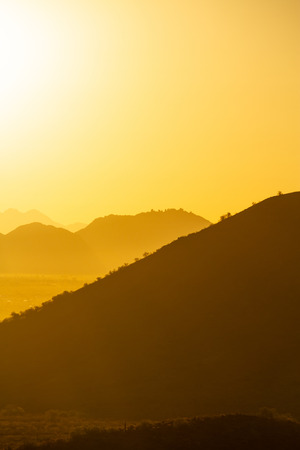 The sun rising over the mountains of the Arizona desert with natural warm hues.の写真素材