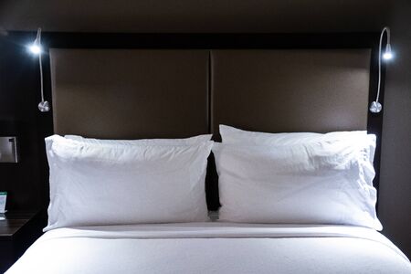 A hotel bed perfectly made and waiting for a guest needing rest.の写真素材