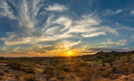 A sunset over the Sonoran Desert of Arizona with high altitude clouds panorama.の写真素材