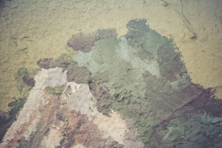 Abstract background in yellow and green on a very rough and textured background.