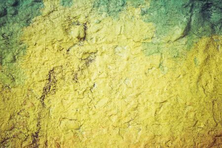 Abstract background in yellow and green on a very rough and textured background.の写真素材