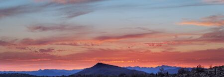 A sunset over a distant mountain in the Sonoran Desert of Arizona panoramaの写真素材