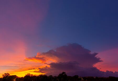 Panorama of thunderstorm clouds lit up in the colors of sunset.の写真素材