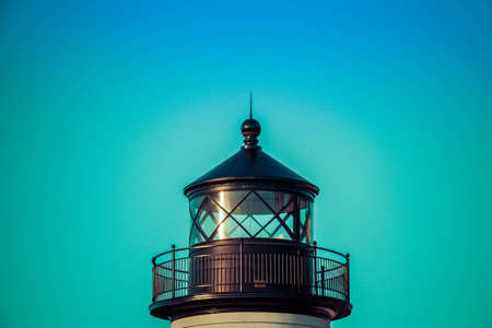 The top of a lighthouse in daylight against a cloudless blue sky.の写真素材
