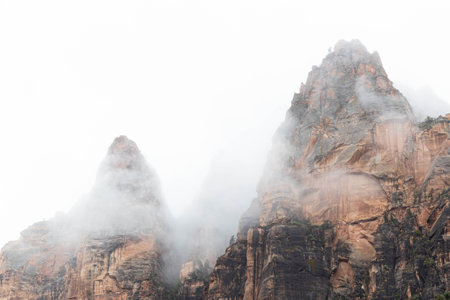 The mountain peaks of Zion National Park piercing through and overcast sky creating neutral space to add text or graphics.の写真素材