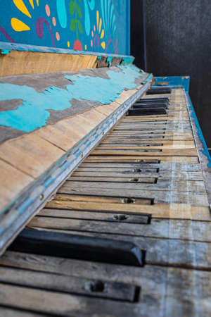 A close of the keys on an old, weathered piano with selective focus on some keys and other keys missing.の写真素材