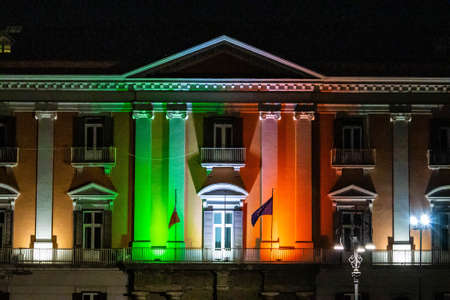 Builds in Naples Italy at night displaying the colors of the Italian flag in lights around the...