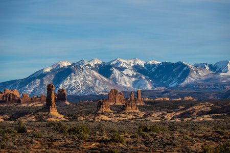 Rock formations with distant snow-covered mountains in the distance in Arches National Park.の写真素材