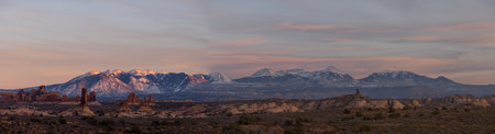 Panorama of rock formations with distant snow-covered mountains in the distance in Arches National Park.の写真素材