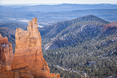 Bryce Canyon accented in freshly fallen snow and distant mountains and brilliantly colored orange cliffs.の写真素材