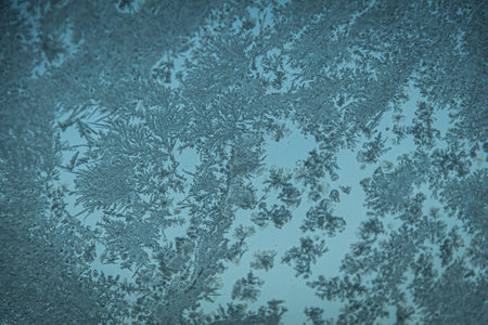 Frost ice crystals on the surface of glass in blue tones.の写真素材