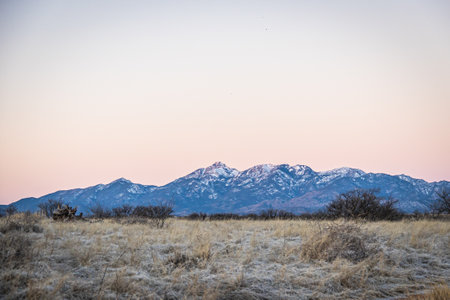 Distant mountain range with hills covered in grass in the forground in Arizona.の写真素材
