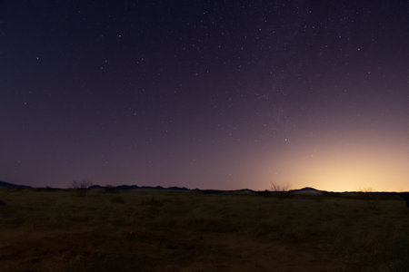 The starry night sky appearing at the end of daylight over the landscape.の写真素材