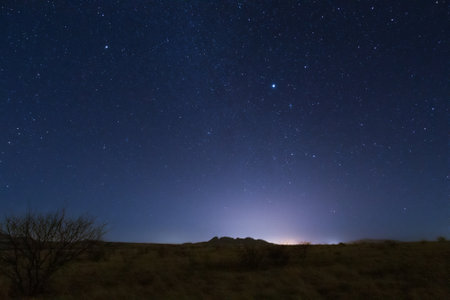 The starry night sky appearing at the end of daylight over the landscape.の写真素材
