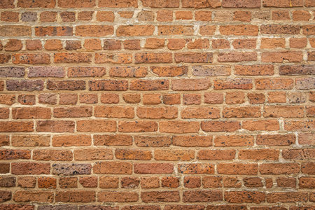 A blank red brick wall that is heavily weathered with plenty of copy spaceの写真素材