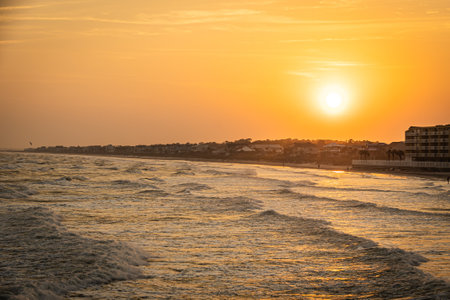Looking at the sun setting along the shores of South Carolina with people walking the beach.の写真素材