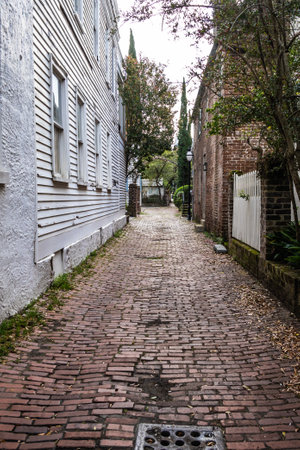 Looking down an alley with a brick surface and ambient light from the cloudy skies.の写真素材