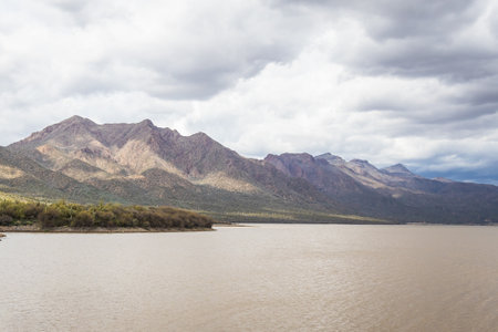 Looking over a mountain lake with soft light from the cloudy skies.の写真素材
