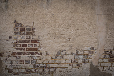 A blank red brick wall with stucco that is heavily weathered with plenty of copy spaceの写真素材