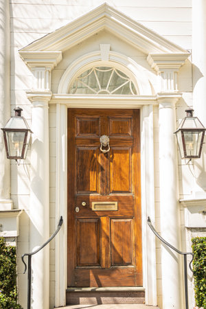 A colonial style front door with an eccentric door frame in sunlight.の写真素材