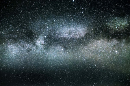 The Milky Way galaxy core in a glowing blue light with lots of stars.の写真素材