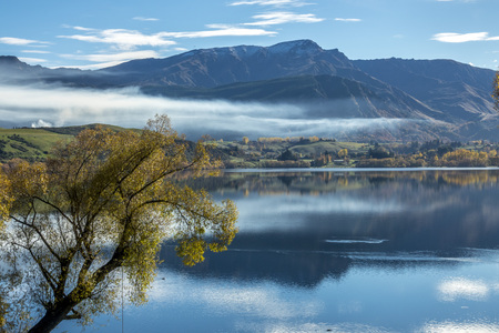 The lake Hayes with colourful trees near Arrow town in Autumn south island of New Zealand.の写真素材