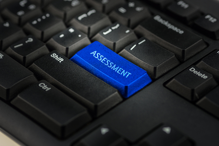 Close-up view on conceptual keyboard - assessment (blue key)の写真素材
