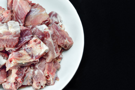 Heap of raw pork bones on white plateの写真素材