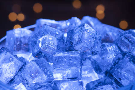 Wet ice close-up with warm garlands in the backgroundの写真素材