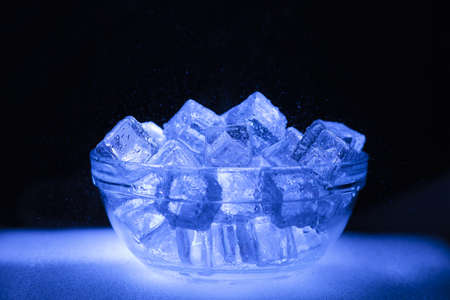 Bowl of wet ice with dark backgroundの写真素材