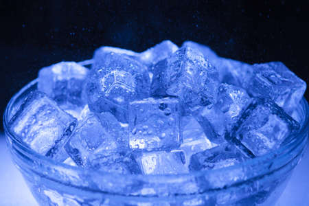 Bowl of wet ice close-up with water drops falling overの写真素材