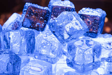 Ice cubes pile close-up with warm backgroundの写真素材