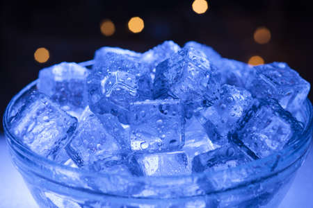 Bowl of wet ice close-up with garlands in the backgroundの写真素材