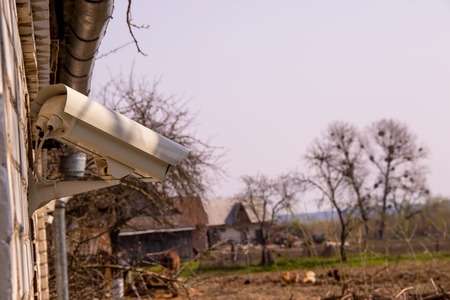 The video surveillance camera is watching behind the backyards of the village houseの写真素材