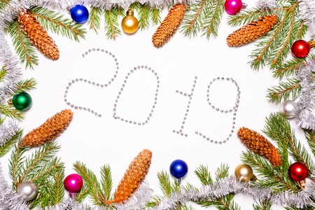 Christmas frame with Christmas tree branches, toys and cones Christmas decorations and the figure...