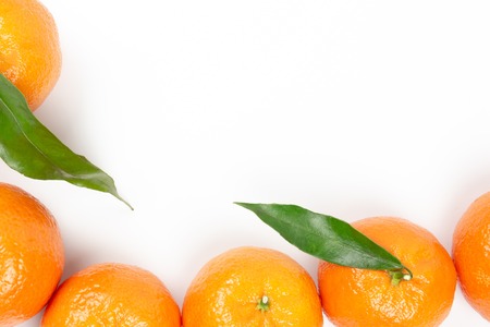 Ripe orange tangerines with green leaves on a white background with copyspace and one tangerine in...