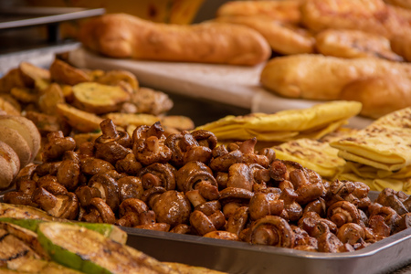 A plate of khachapuri in the background of shawarma, fried mushrooms and vegetableの写真素材