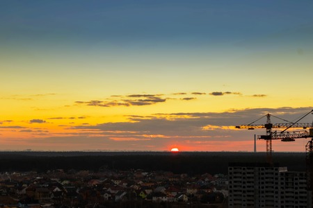 Crane,Construction tower crane equipment over building construction site silhouette,Industrial construction cranes on amazing sunset sky background,technology transportation material to high site.の写真素材