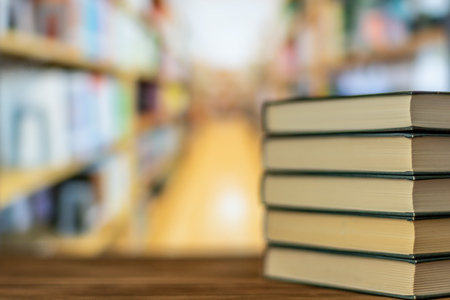 Open book on the desk in the library room, blurred and book shelves back to school concept for...