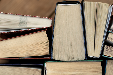 Many Books Piles. Hardback books on wooden table. Back to school. Copy space