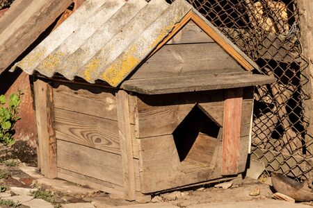 simple wooden dog house in rural farm under sunの写真素材