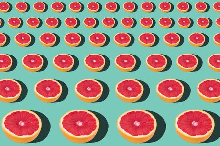 Tasty ripe grapefruit slices on blue background, flat lay
