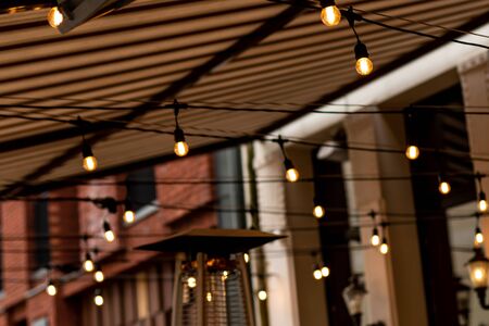 Modern lamp from metal with Edison bulb in outside restaurant cafeの写真素材