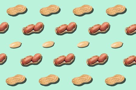 Cracked peanut minimal pattern on light green background backdrop food nut textureの写真素材