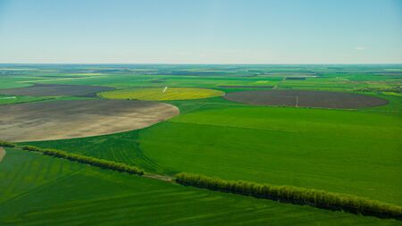 Aerial view over rural area with rape fields and green areas