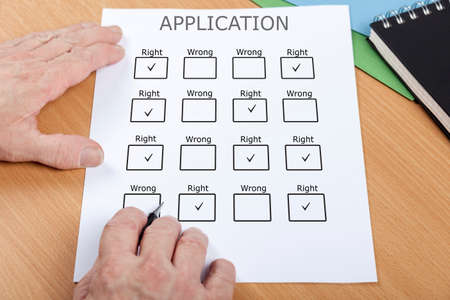 Person at their desk ticking all the right boxes on an application formの写真素材