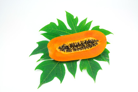 Haft cut papaya fruit and papaya leaf isolated over white backgroundの写真素材
